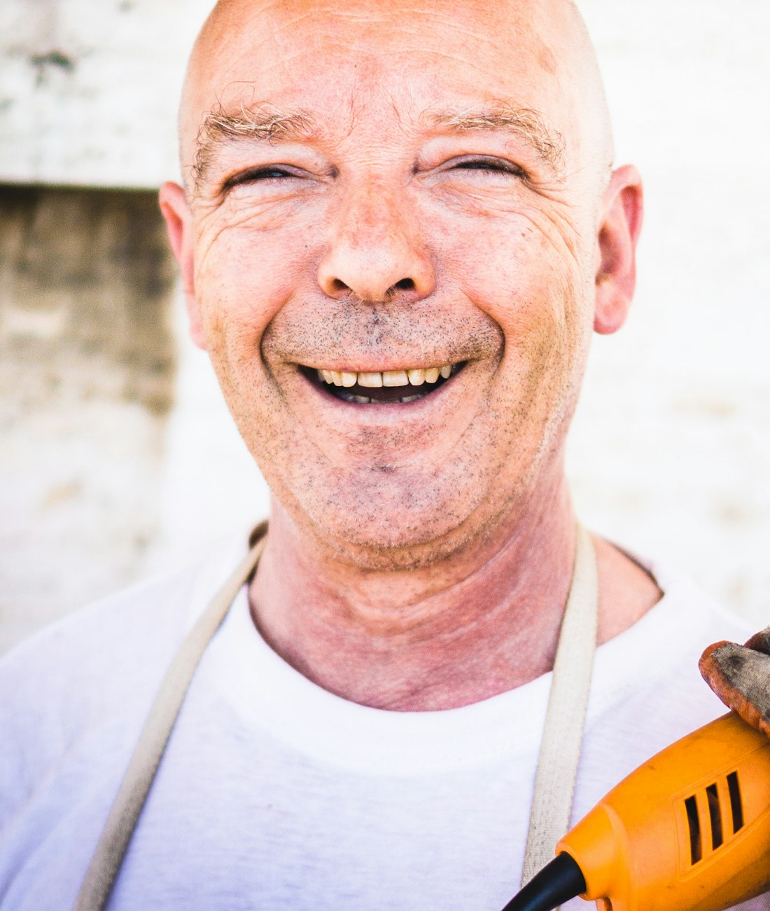 Artisan souriant, outil à la main