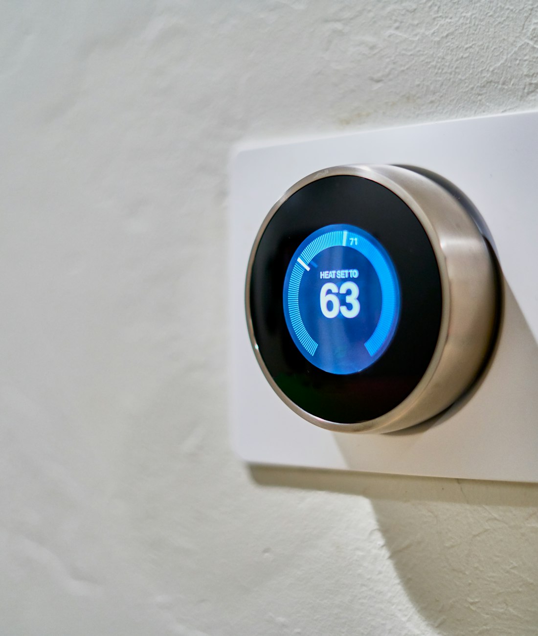 Thermostat connecté au mur d'une maison